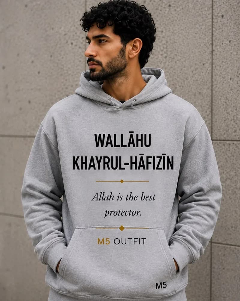 Model wearing a grey M5 Outfit hoodie printed with the Arabic and English phrase Wallahu Khayrul-Hafizin