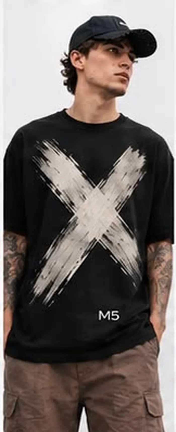 Model wearing a black M5 Outfit T-shirt printed with a bold white brush-stroke X