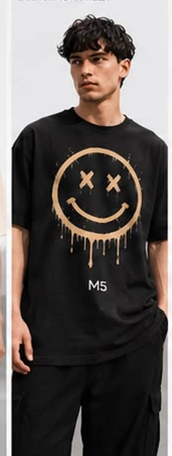 Model wearing a black M5 Outfit T-shirt printed with a dripping smiley face graphic