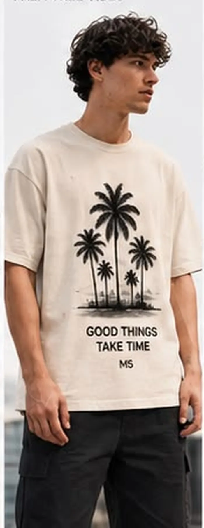 Model wearing a cream M5 Outfit T-shirt printed with palm trees and Good Things Take Time text