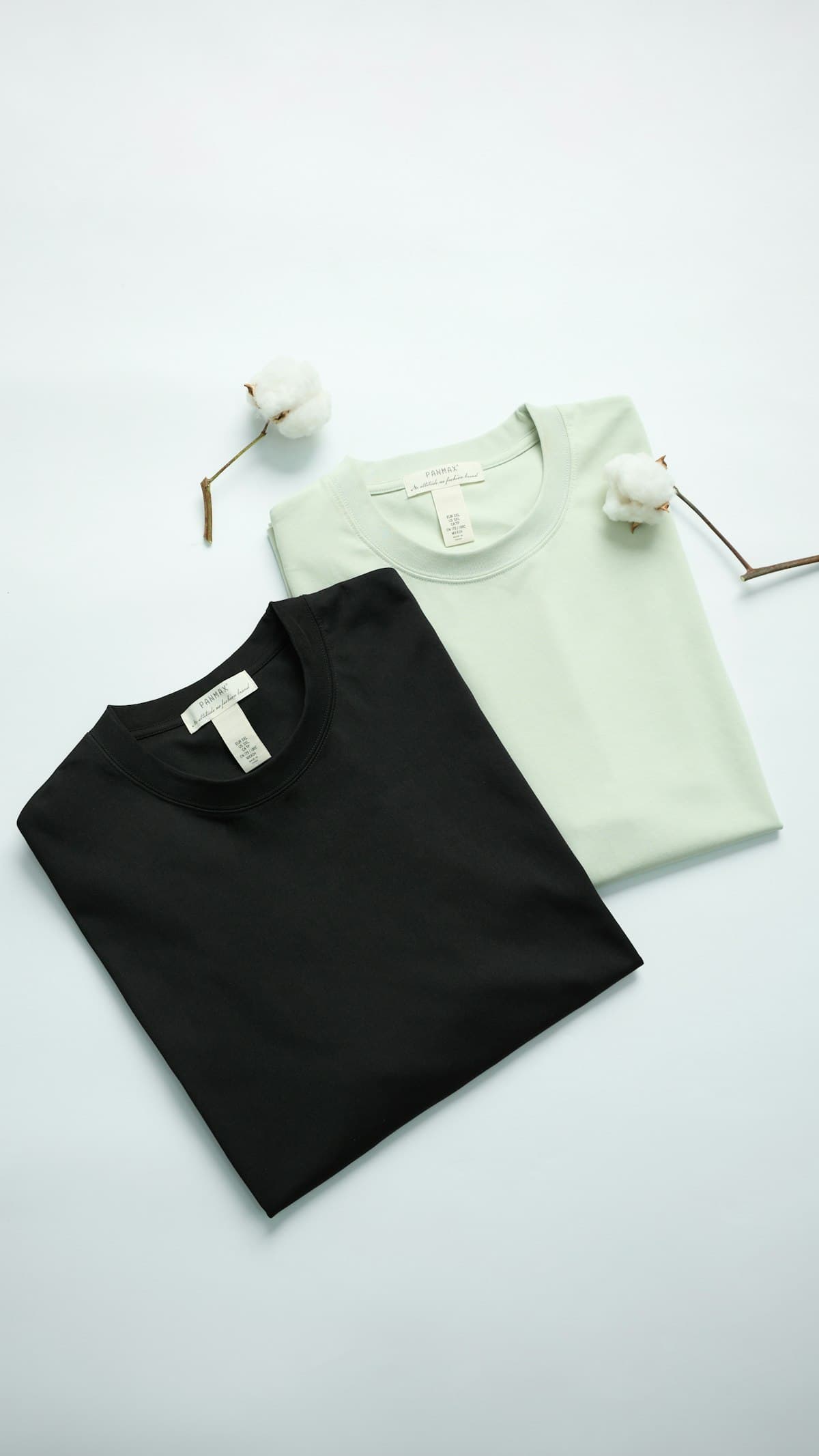 Folded 100% cotton M5 Outfit garments with raw cotton sprigs
